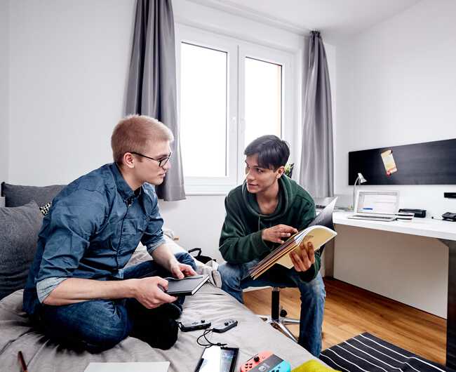 [Translate to Englisch:] Zwei Studenten lernen gemeinsam in Studentenappartement