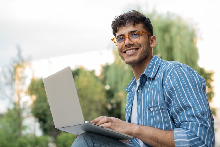 Junger Mann mit Brille am Laptop
