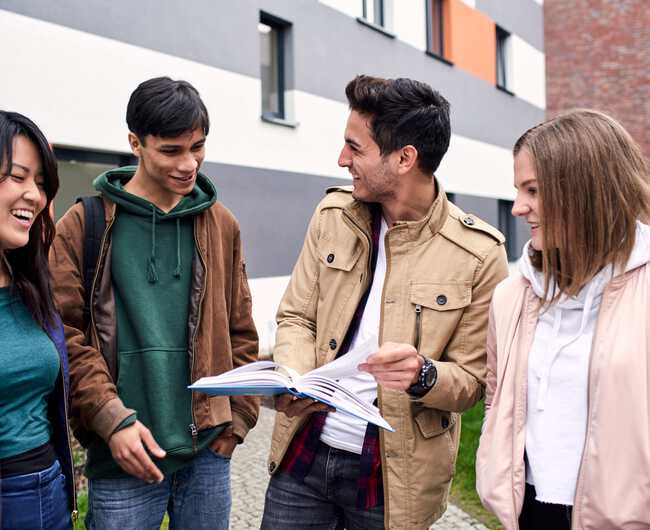 Gruppe von jungen Studenten stehen zusammen und lachen